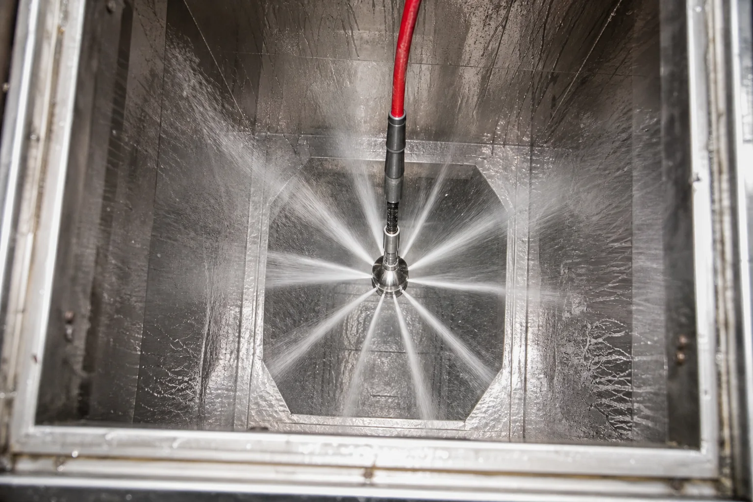 Professional 360-degree rotary high-pressure sprayer rinsing an apartment trash chute