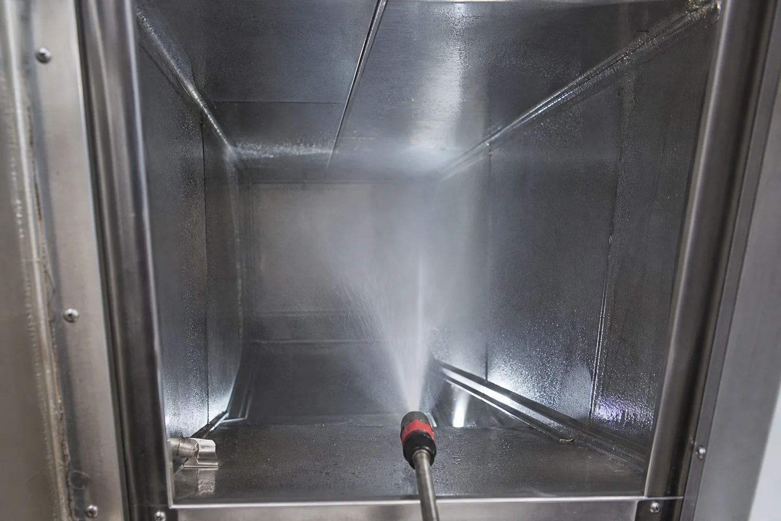 Fine deodorizer mist being applied inside a freshly cleaned apartment trash chute